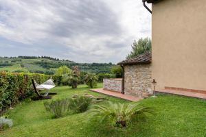 a garden with a hammock and a house at Tenuta Virgilio Colline del Chianti in Tavarnelle in Val di Pesa