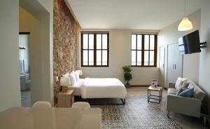 a bedroom with a bed and a couch and a tv at AmazINN Places Casa Fortaleza in Panama City