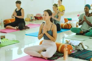 a group of people sitting in a yoga class at Satya Yoga Ashram Rishikesh in Narendranagar