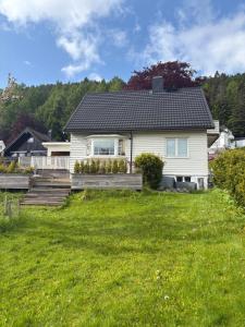 a white house with a lawn in front of it at Entire home with pool and garden in Ålesund