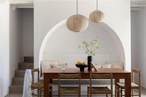 a dining room with a wooden table and chairs at Blue Rock Villa in Kalo Livadi