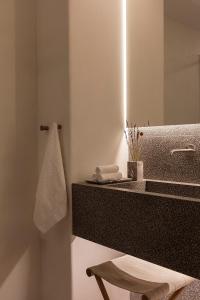 un baño con lavabo y espejo en Blue Rock Villa, en Playa Kalo Livadi 23 fotos más