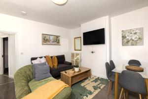 a living room with a couch and a table at Priory house - home away from home in Dartford