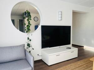 soggiorno con TV su un armadietto bianco di Bright Modern Apartment - Central Kuressaare a Kuressaare
