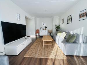 un soggiorno con una grande TV e un divano di Bright Modern Apartment - Central Kuressaare a Kuressaare
