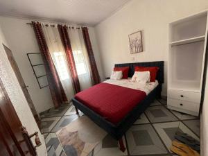 een slaapkamer met een bed met rode kussens erop bij Tivana in Kigali