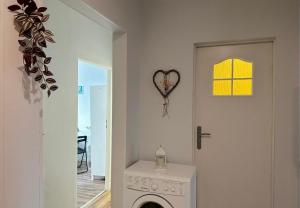 a white laundry room with a door with a heart on the wall at Morska Aqua Therapy Room nr 3 in Gdynia