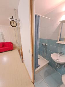 a bathroom with a sink and a toilet and a clock at B42 Cozy in Budapest