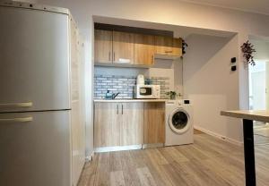 a kitchen with a refrigerator and a washing machine at Morska Aqua Therapy Room nr 3 in Gdynia +11 photos