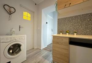 a laundry room with a washing machine in a kitchen at Morska Aqua Therapy Room nr 3 in Gdynia