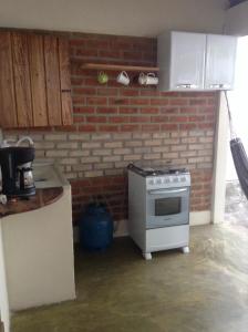 a kitchen with a stove and a brick wall at Casa Repousar in Lençóis