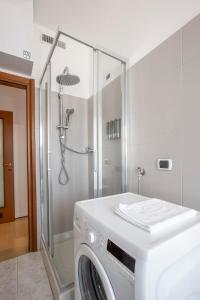 a washing machine in a bathroom with a shower at Como Lake, 6 Posti, Vista Monti, Clima e Garage in Lecco