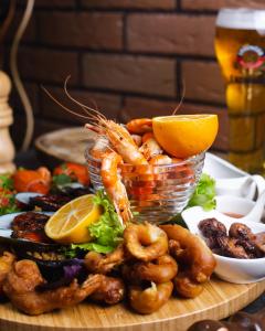 a plate of shrimp and vegetables with a glass of beer at Golden Tulip Pattaya Beachfront Resort in Pattaya North