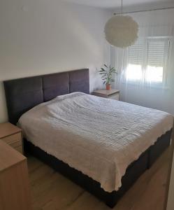 a bedroom with a large bed and a potted plant at Tonka 1 in Podstrana
