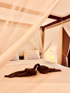 a robe laying on a bed in a room at Lagom Guest House in Gili Air