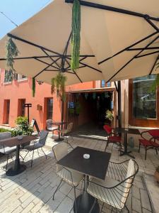 a patio with tables and chairs and an umbrella at Te Beu Rooms in Vlorë