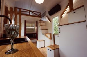 a kitchen in a tiny house with a wine glass on a counter at Tajnikowo Sekretny Tiny House Anyżek in Lubiana