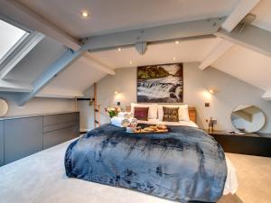 ein Schlafzimmer mit einem großen Bett mit einer großen blauen Decke in der Unterkunft The Nook by Luxury Travel Emporium in Askrigg