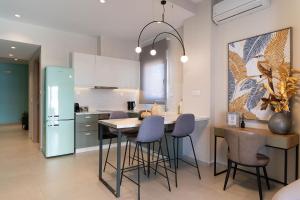 a kitchen with a table and chairs and a refrigerator at Zen Luxury Apartments in Xanthi