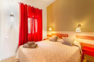 1 dormitorio con 1 cama con cortinas rojas en Brisa del Sur, en Maspalomas 17 fotos más