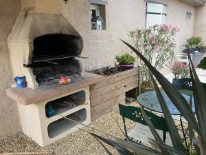 a outdoor pizza oven in a garden with a table at l'orchidée in Talais