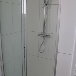 a shower with a glass door with a shower coil at Resort Rhederlaagse Meren in Lathum +34 photos