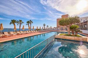 duży basen z krzesłami i palmami w obiekcie Universal Hotel Romantica w miejscowości Colonia Sant Jordi