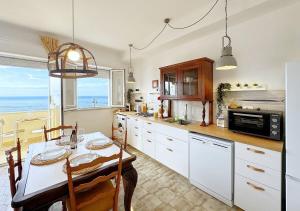 a kitchen with a table and a dining room at Solemar Sicilia - Casa Dolce in Bagheria