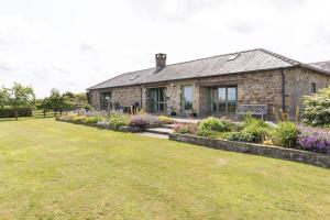 a stone house with a garden in front of it at East Lodge, Yorkshire in Bedale