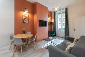 un salon avec un canapé et une table dans l'établissement Let's- 2 and 1 - Sweet Voltaire, à Lyon