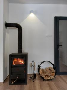a stove in a room with a pile of logs at House For Rest VIN in Kolašin