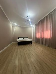 a bedroom with a bed in a room with a window at Park home Uralsk in Uralsk