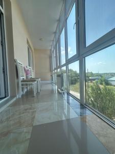 a large room with windows and a table and chairs at Park home Uralsk in Uralsk
