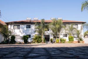 a large white building with trees in front of it at The Residence Apartments in Nyanda