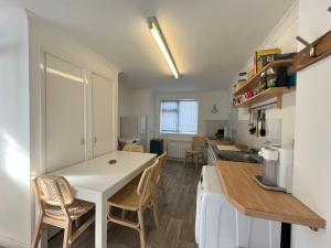 Una cocina con una mesa y sillas en una habitación. en 2 Bed Beach Apartment with Pool!, en Mawgan Porth