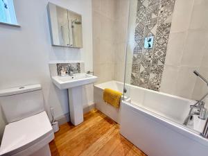 Un baño con lavabo, bañera e inodoro. en The Manor Coach House, en Canterbury 13 fotos más