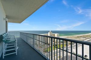 Emerald Dolphin Unit 1450 في شاطئ بينساكولا: شرفة مع كرسي وإطلالة على المحيط