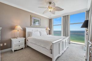 Emerald Dolphin Unit 1450 في شاطئ بينساكولا: غرفة نوم بسرير أبيض ونافذة كبيرة