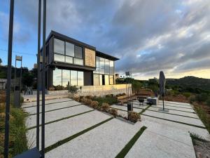 a house with glass windows on top of a parking lot at AlFahed Farm in Ajloun