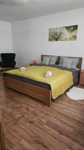 a bedroom with a large bed with a yellow blanket at VárLak in Várbalog
