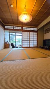 an empty room with a large floor in a room with a chandelier at 海の風 in Wakayama