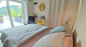 a bedroom with a bed and a window and a chair at La Chambre aux Pommes - Poupehan sur Semois in Bouillon