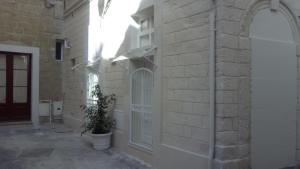 eine Ziegelmauer mit einer Pflanze in einem Topf neben einem Gebäude in der Unterkunft Casa Anna in Lecce