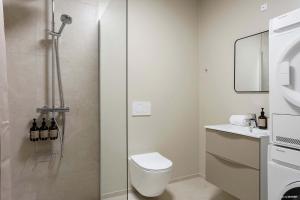 a bathroom with a shower with a toilet and a sink at Modern Easy-Access 1BR Apartment in Midtown in Aarhus