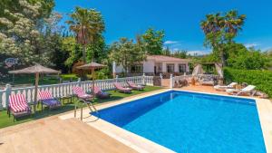 einen Pool mit Stühlen und Sonnenschirmen vor einem Haus in der Unterkunft Casa Rural Marquez Ronda by Ruralidays in Ronda