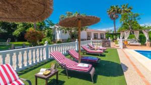eine Gruppe von Stühlen und Sonnenschirmen neben einem Pool in der Unterkunft Casa Rural Marquez Ronda by Ruralidays in Ronda