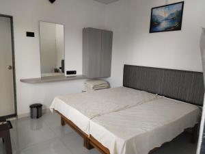una camera da letto con un letto con uno specchio sul muro di Malhar Baug Resort a Nagaon