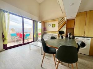 Una cocina y una sala de estar con mesa y sillas. en Apartment with Balcony & Pool in La Rochelle, en La Rochelle