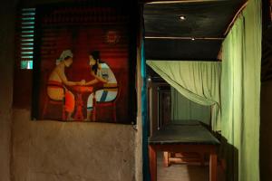 a painting on the wall of a room with a bench at Ella Village House in Ella +2 photos