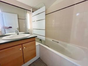 Un baño con lavabo, bañera y espejo. en Apartment with Balcony & Pool in La Rochelle, en La Rochelle